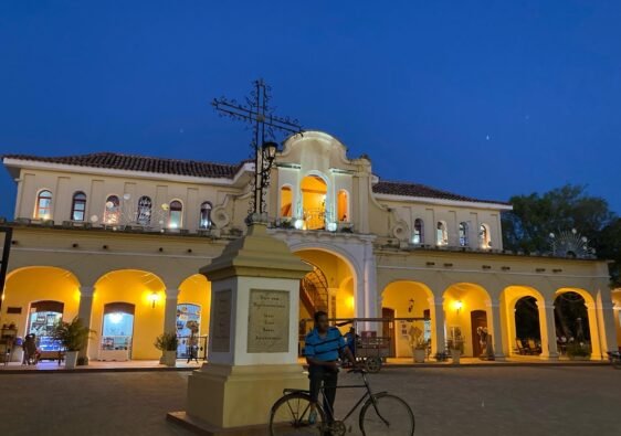 Una de las iglesias de Mompox, en la noche y bajo una cruz un habitante de Mompox en su bicicleta