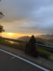 Pausa en la carretera, motociclista mirando el atardecer