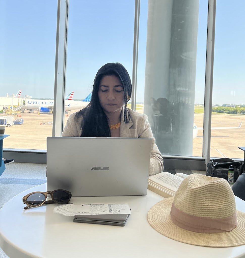 Diana escribiendo en un computador desde el aeropuerto