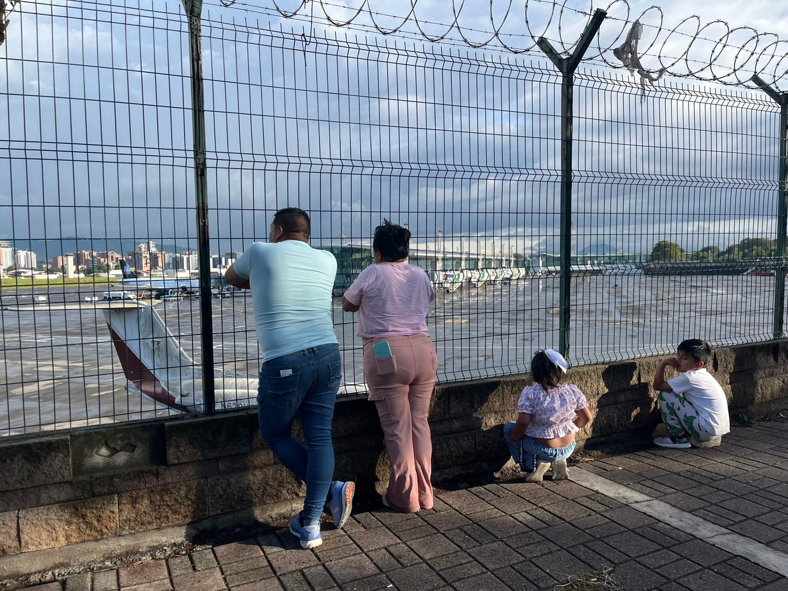 Familia mirando los aviones en el aeropuerto La Aurora en Guatemala