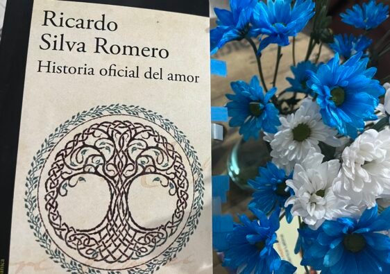 Portada de Historia Oficial del amor de Ricardo Silva Romero junto a unas flores azules y blancas