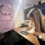 La escritora Lissa María Reyes Camacho firmando libro