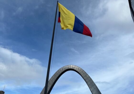 Bandera de Colombia y al fondo el arco de la entrada principal de Corferias en Bogotá