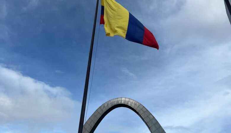 Bandera de Colombia y al fondo el arco de la entrada principal de Corferias en Bogotá