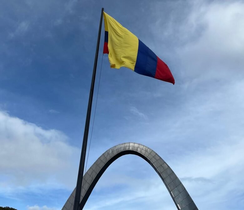 Bandera de Colombia y al fondo el arco de la entrada principal de Corferias en Bogotá