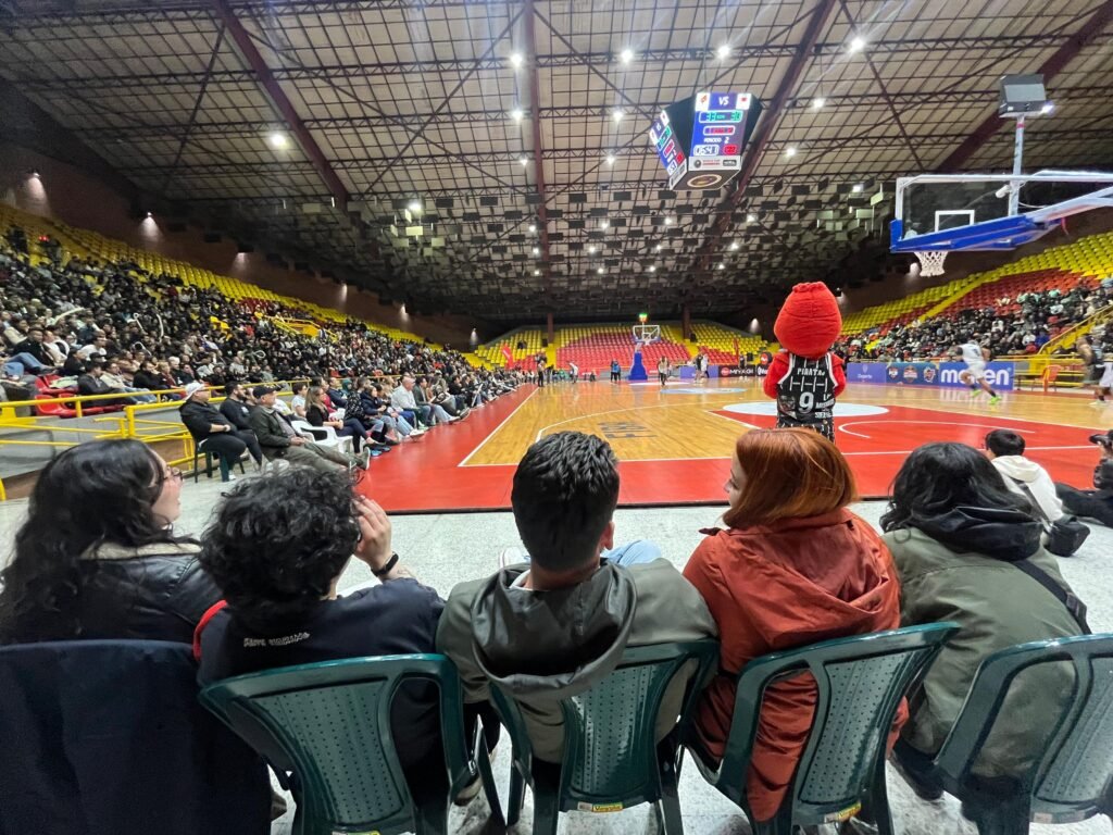 cinco personas viendo el partido de baloncesto en el Coliseo Salitre 