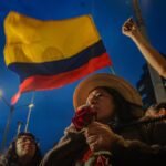 Bandera de Colombia y Aida Quilcué hablando con un micrófono. Foto tomada del Facebook de Aida.
