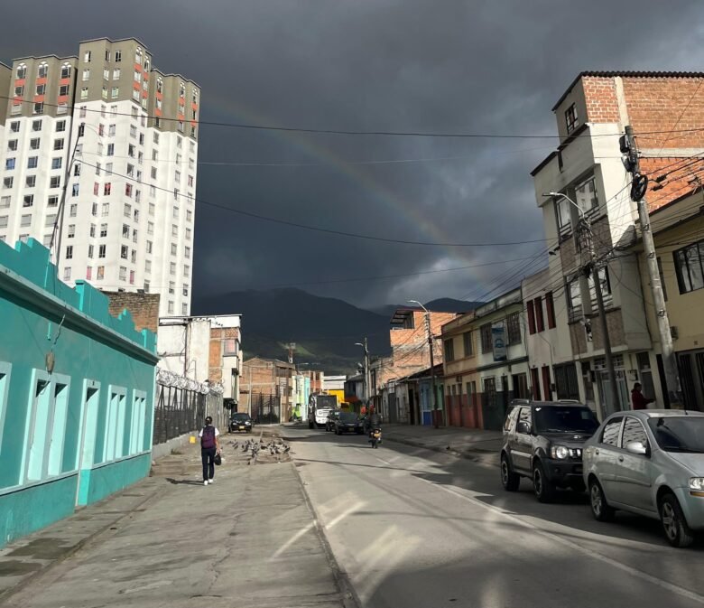 Caminando Pasto hacía el terminal de buses se ve al fondo un arcoíris, en centro de una calle actual de Pasto