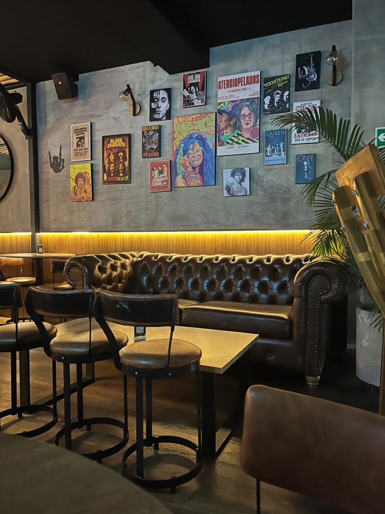 Bar El Mistral. Al fondo se ven unos cuadros de cantantes de rock reconocidos, un sillón grande en cuero dos sillas y una mesa.