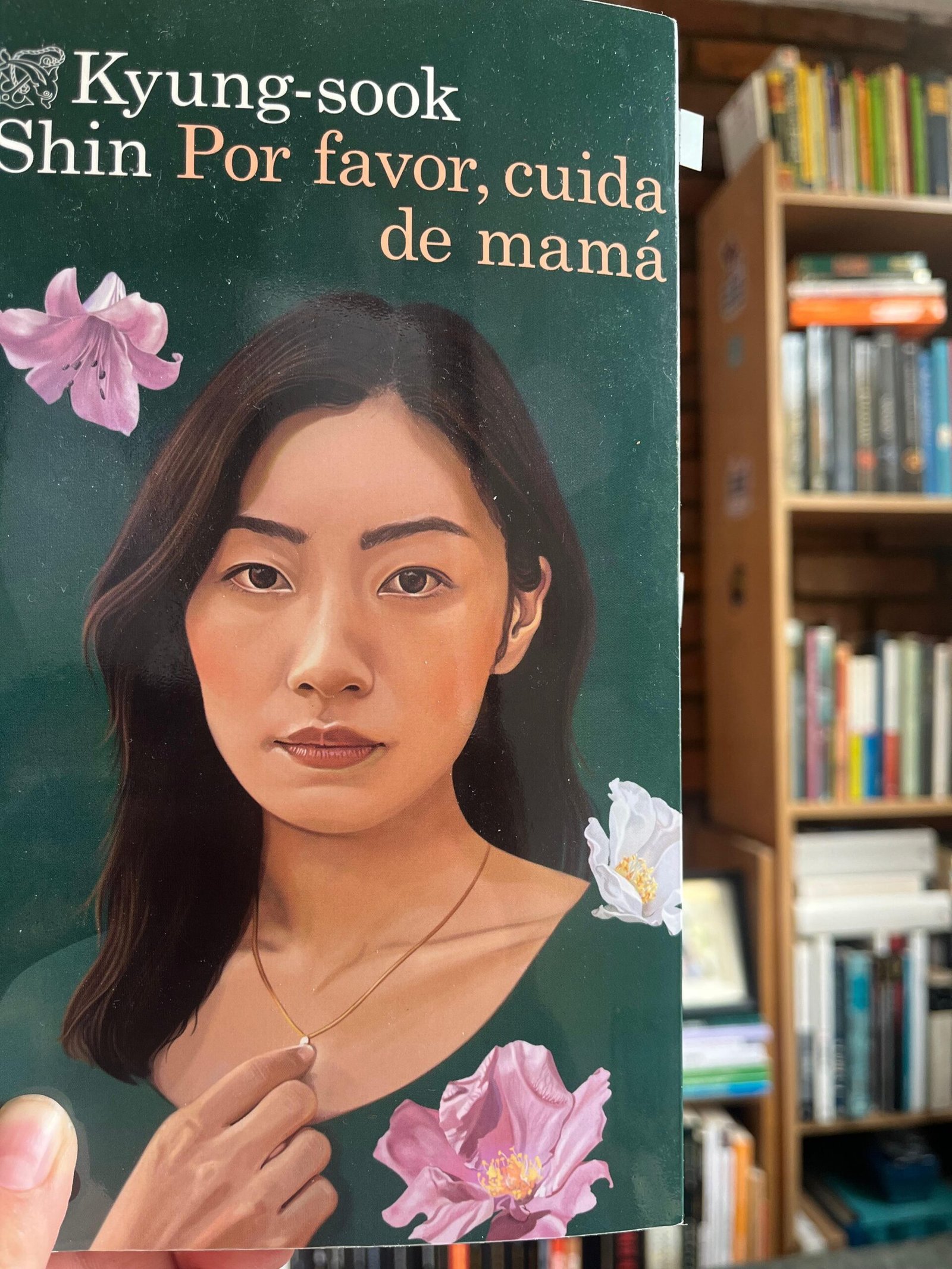 Portada del libro Por favor cuida de mamá, se ve una mujer coreana tocando el dije de su cadena