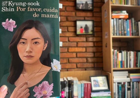 Se ve la portada del libro Por favor cuida a mamá y al lado la biblioteca de Diana