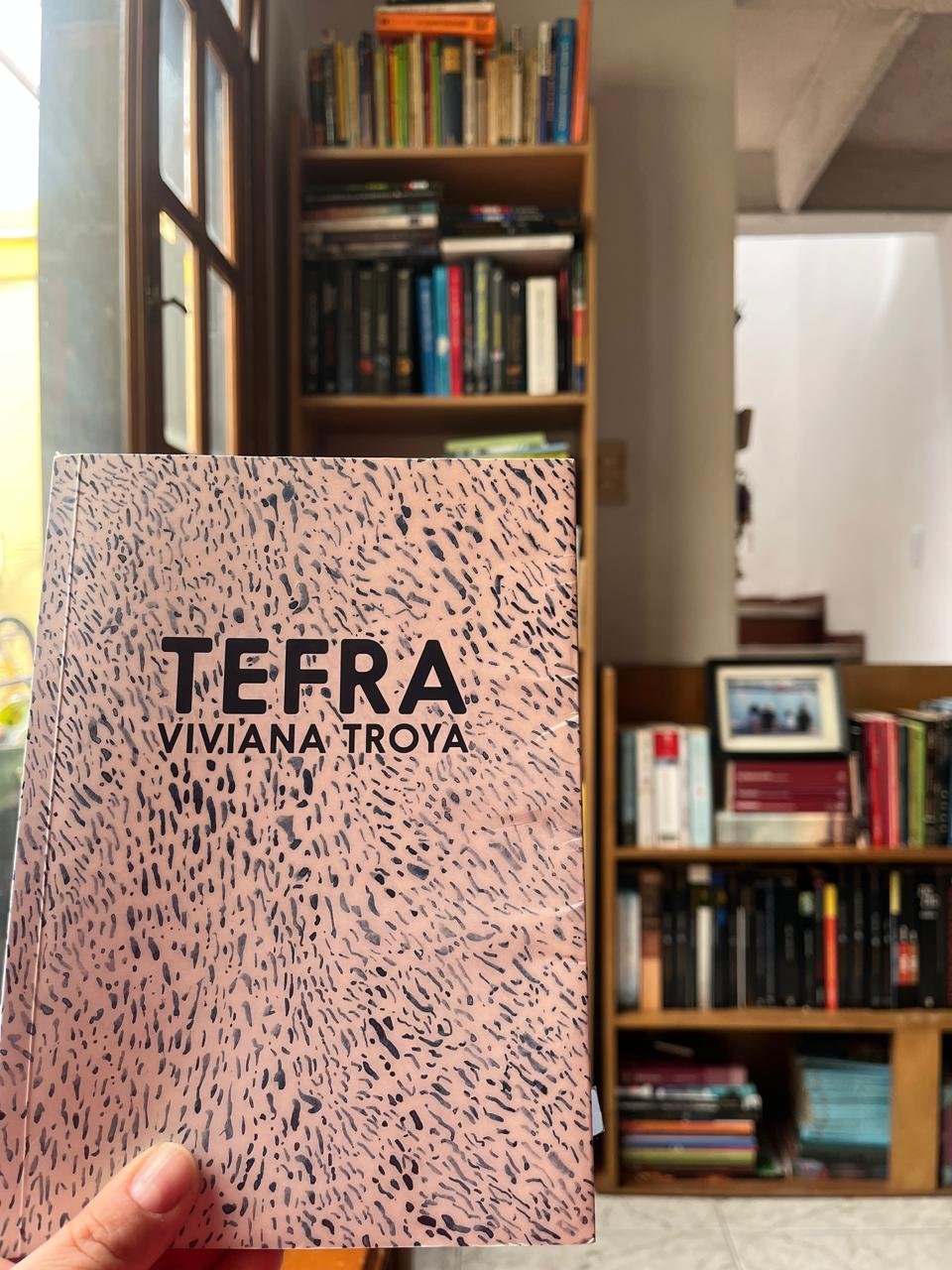 Portada del libro Tefra. Al fondo la biblioteca de Diana