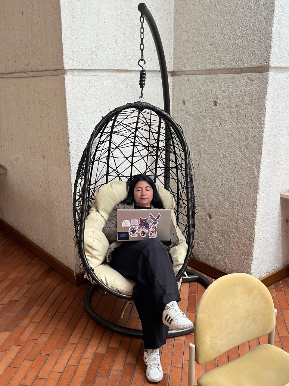 Diana sentada en un nido de la Biblioteca pública Julio Mario Santo Domingo, mientras escribe